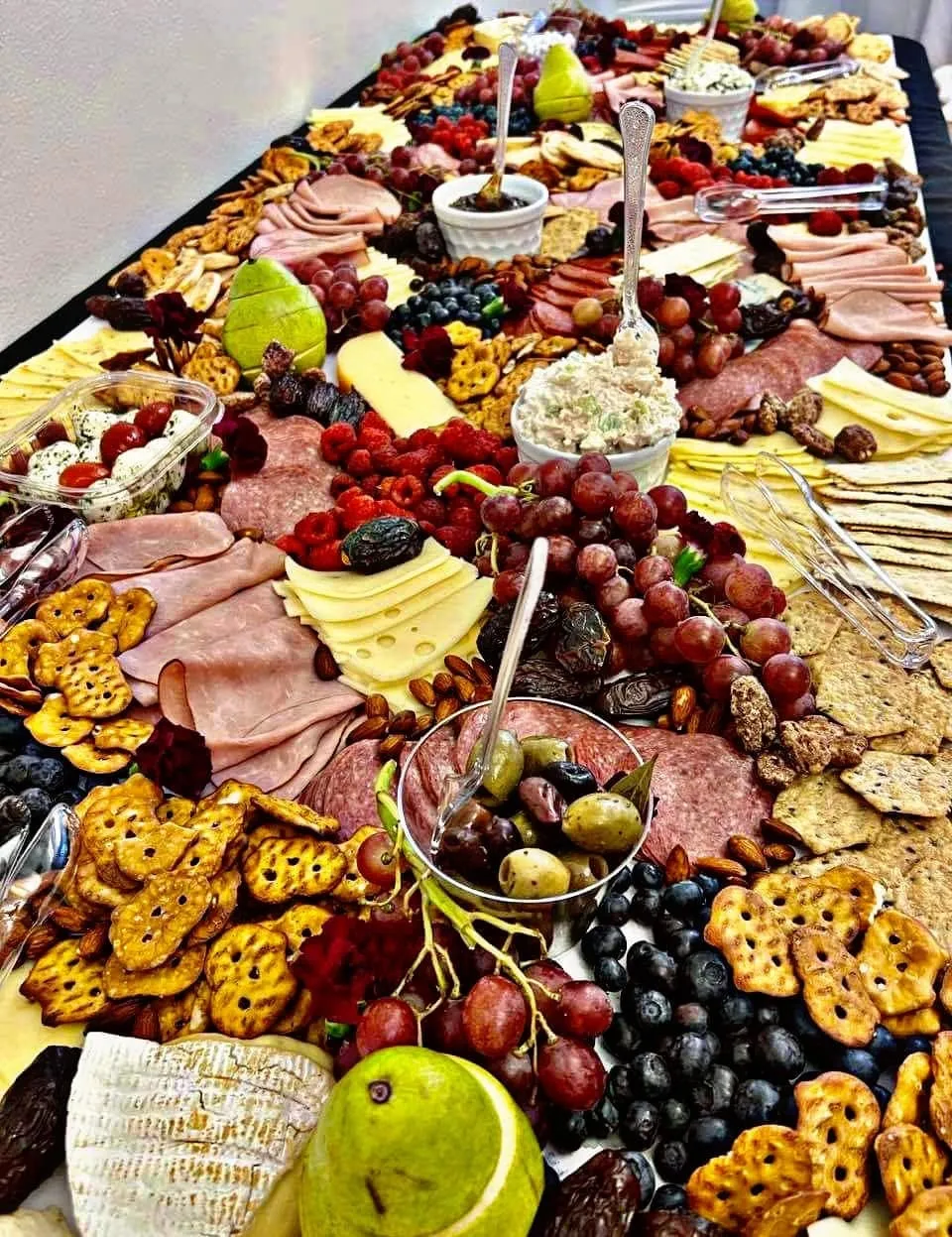 Large charcuterie grazing table prepared by Yvette with meats, cheeses, fruit, crackers, and dips