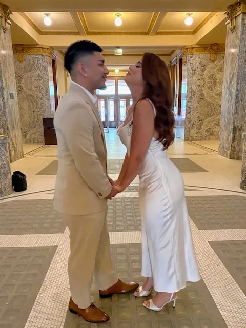 Newlywed couple sharing a kiss inside the historic courthouse