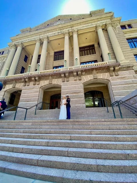 Newlywed couple standing on the steps of the historic Harris County Courthouse