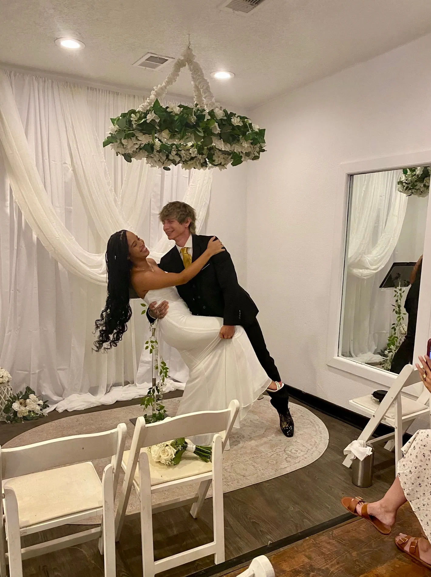 Newlywed groom holding the bride as they smile at each other in the new Twin Flames ceremony room