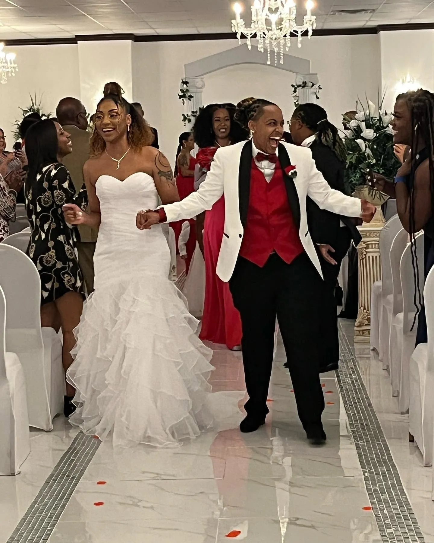 Newlywed couple walking joyfully down the aisle while guests celebrate